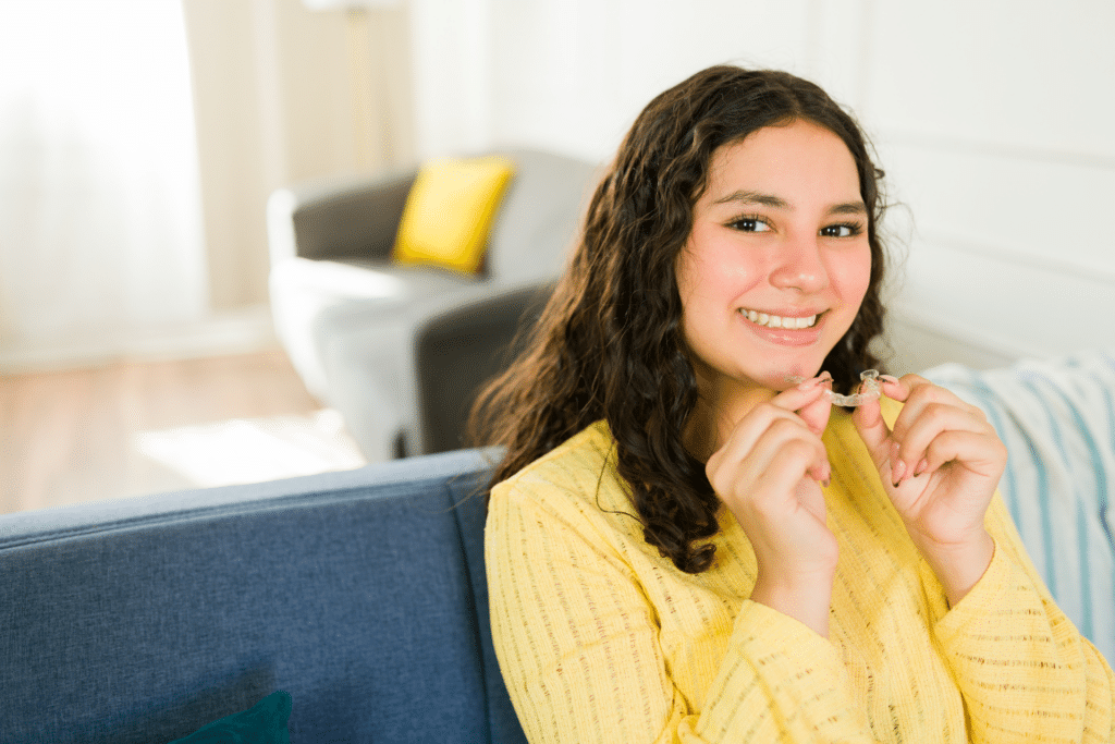Teen holding clear aligners at home as part of a daily orthodontic routine in Elmhurst, IL