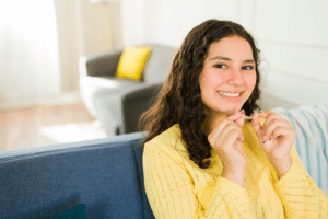 Teen holding clear aligners at home as part of a daily orthodontic routine in Elmhurst, IL